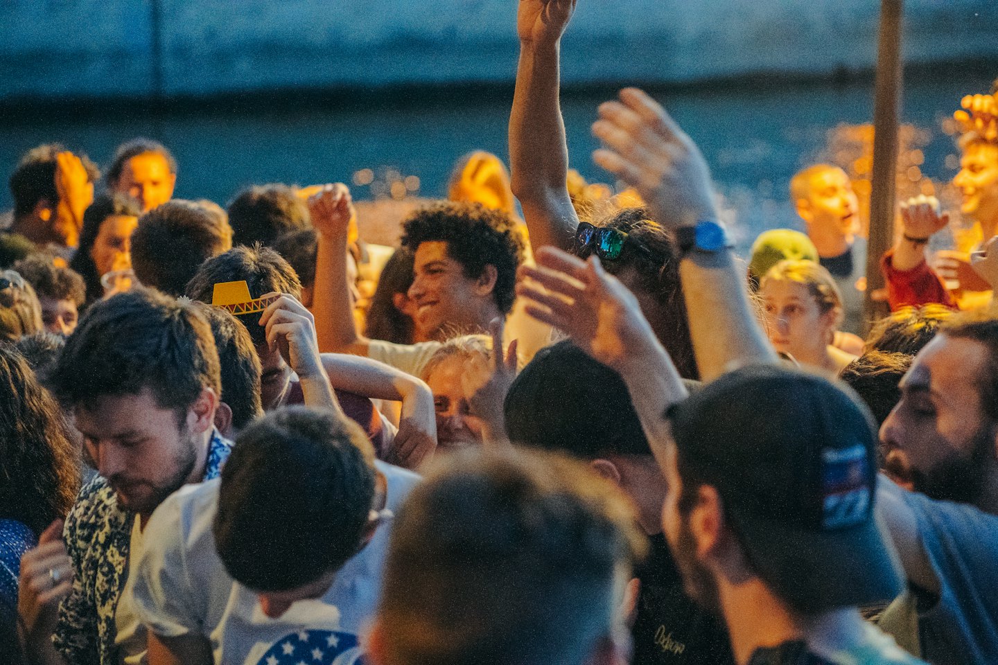 Un gruppo di amici con le braccia alzate a un concerto.
